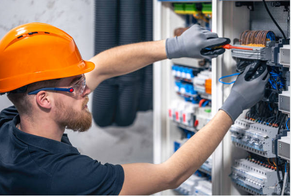 Elektryk pracujący przy rozdzielnicy elektrycznej